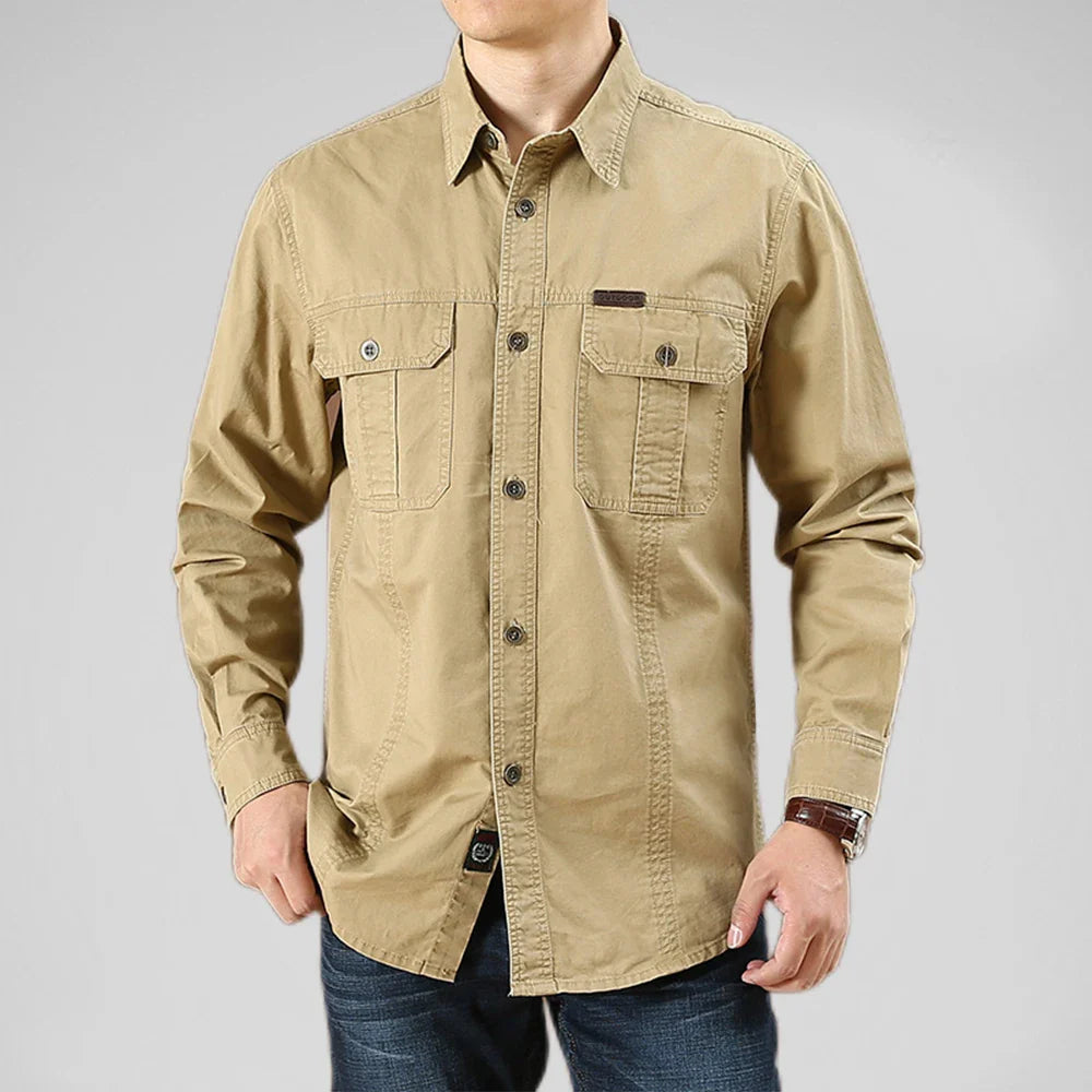 Beige button-up shirt worn by a person on a gray background
