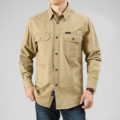 Beige button-up shirt worn by a person on a gray background