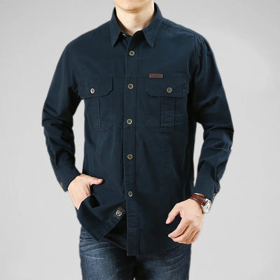 Navy blue button-up shirt worn by a person on a gray background